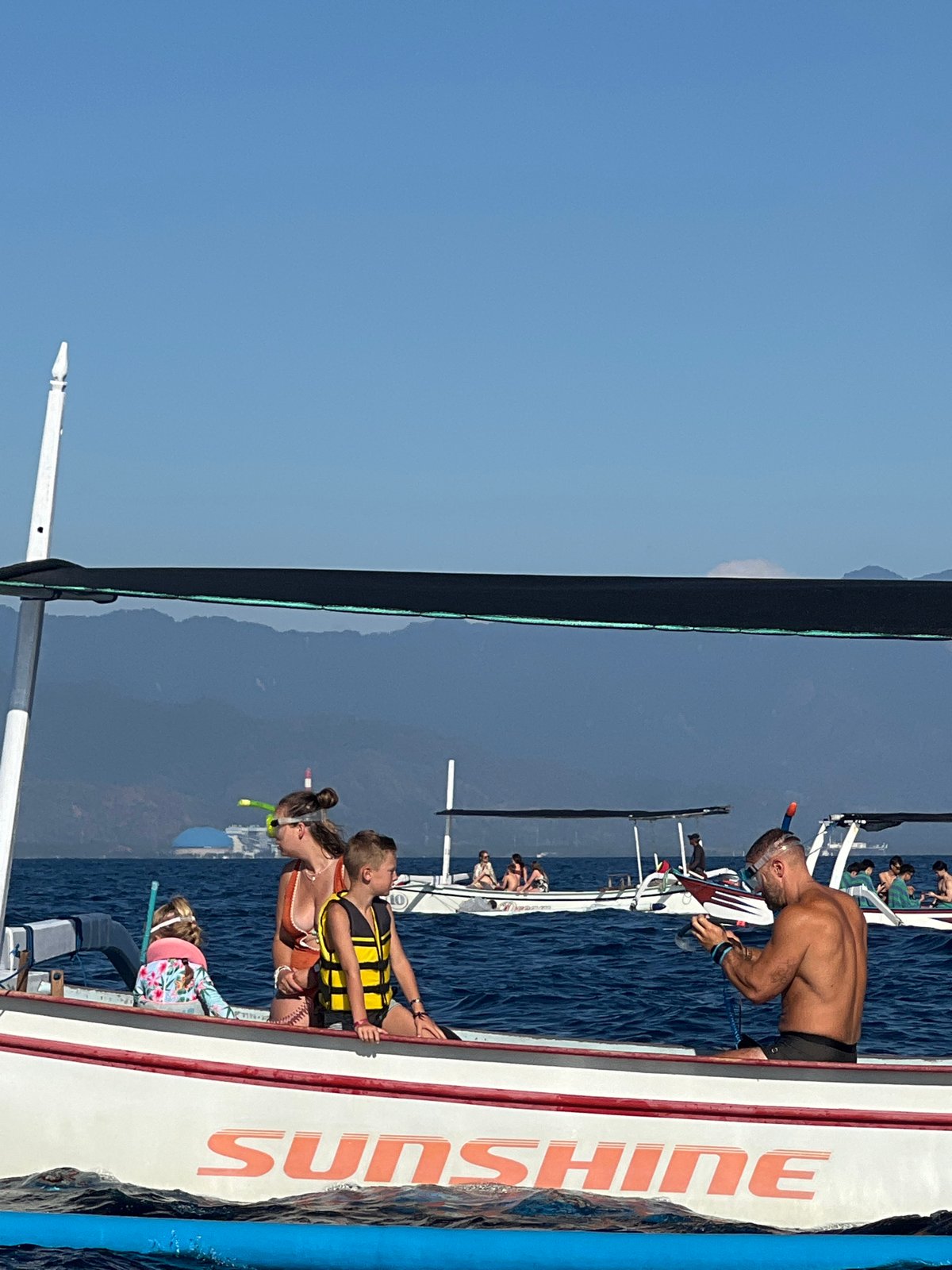 Snorkel trip underway off the Indonesian coast, multiple boats