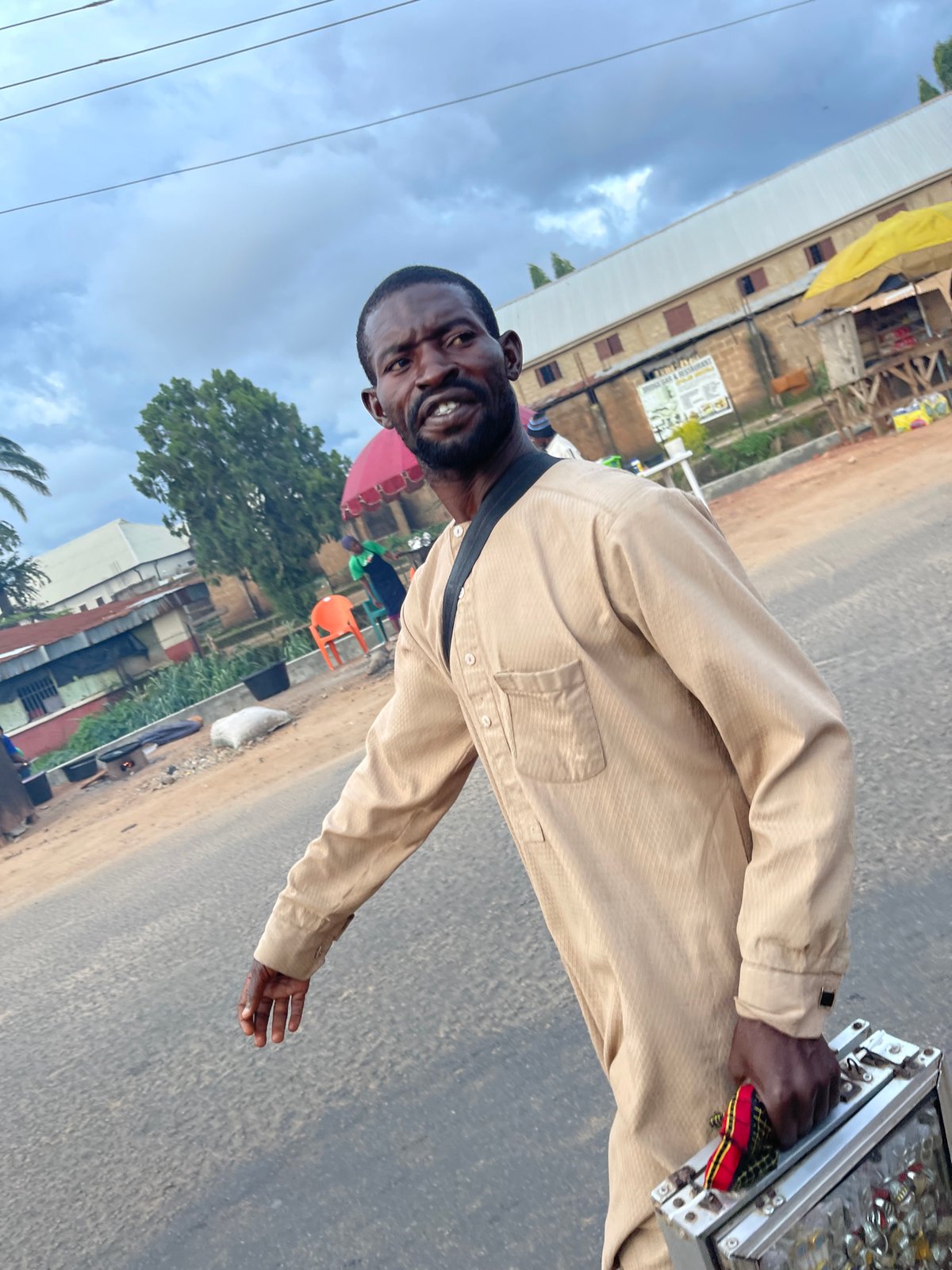 Everyday street life in Jos: grills, bikes, and passing traffic