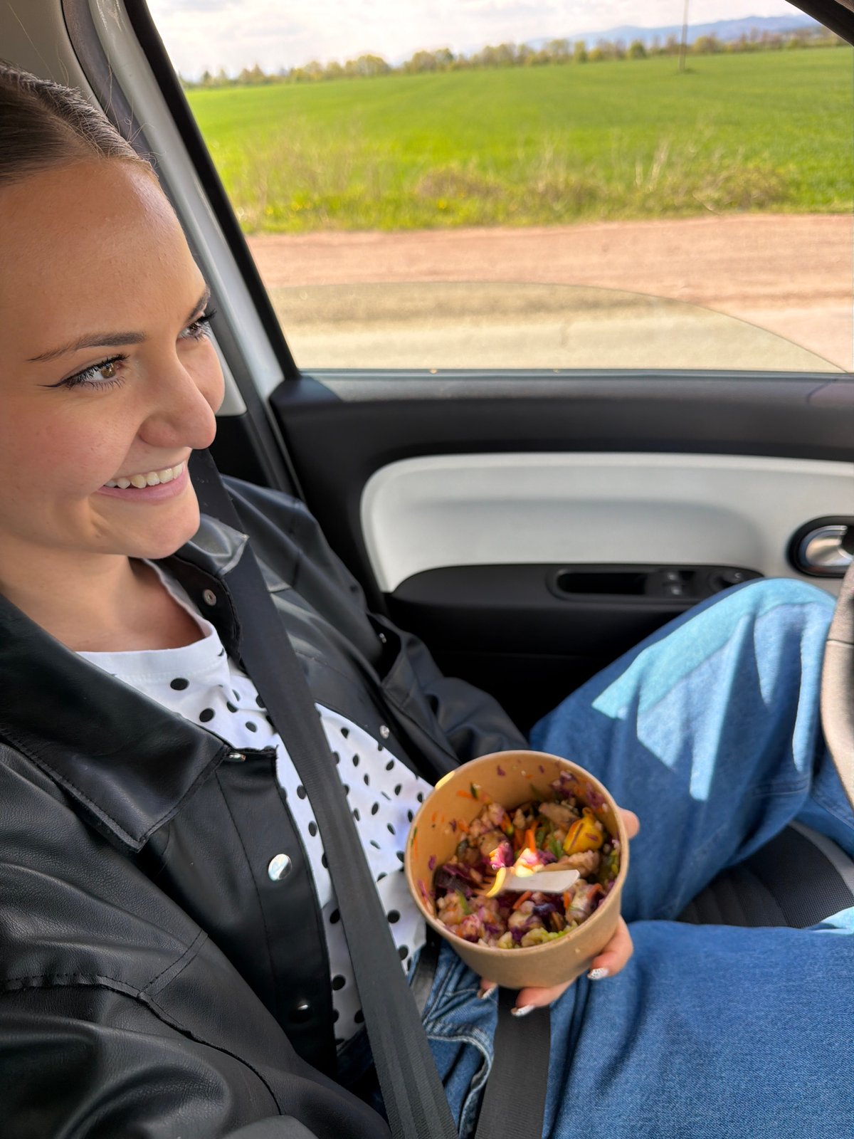 Woman eats from bowl in car outside Sofia