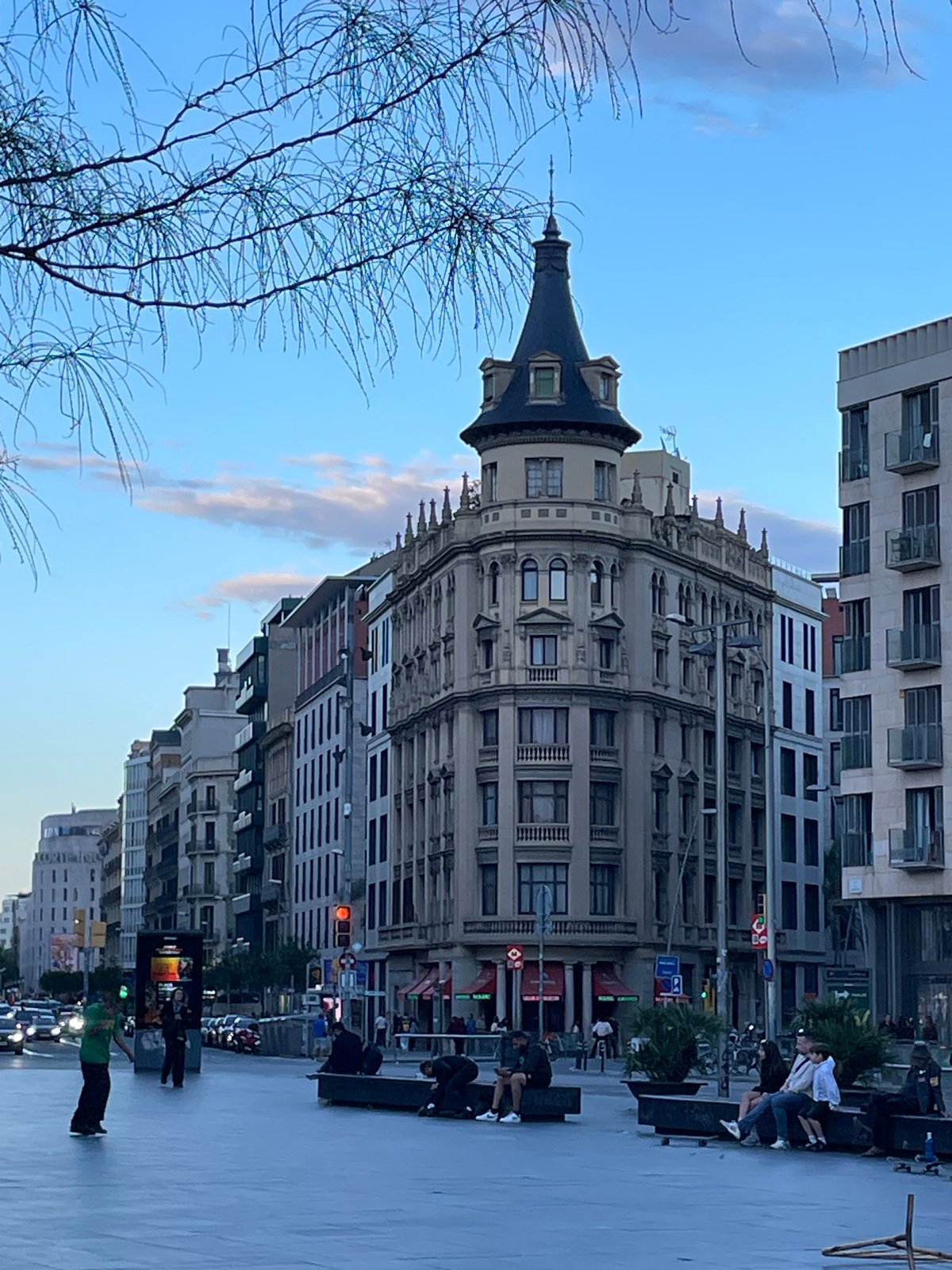Couple strolls past historic Casa Comalat in Barcelona plaza