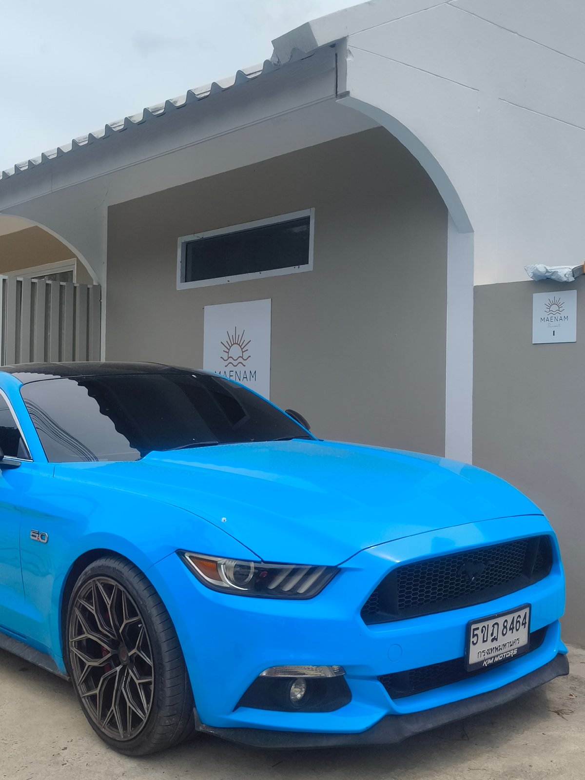 Durian prep at a fruit stall, blue Mustang parked outside