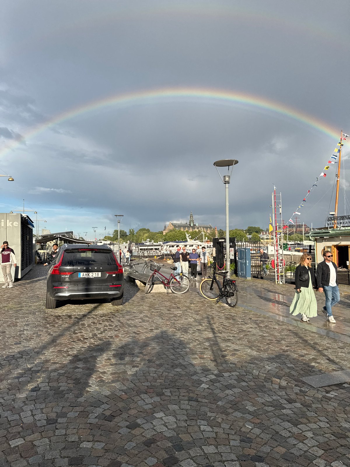 Double rainbow over a harbor, seen from café and table