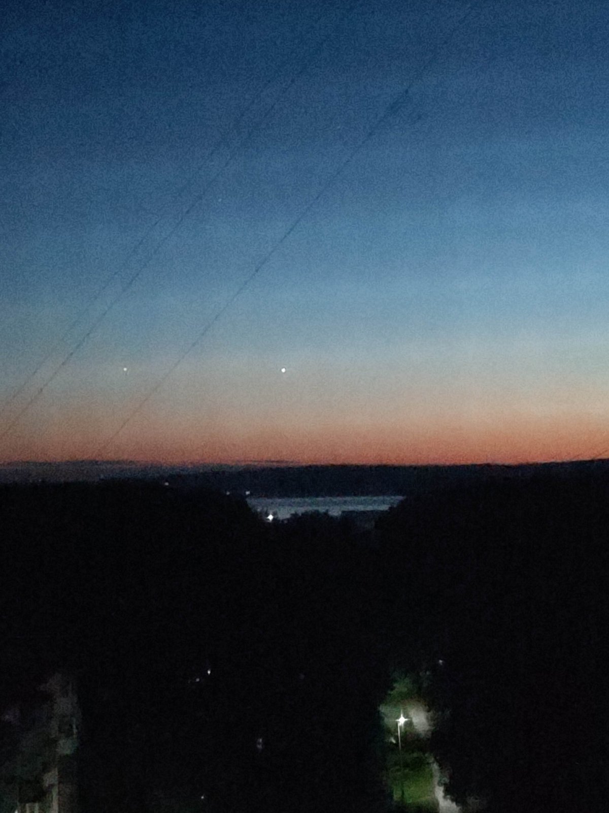 Witness documents twilight transition over urban landscape from elevated position