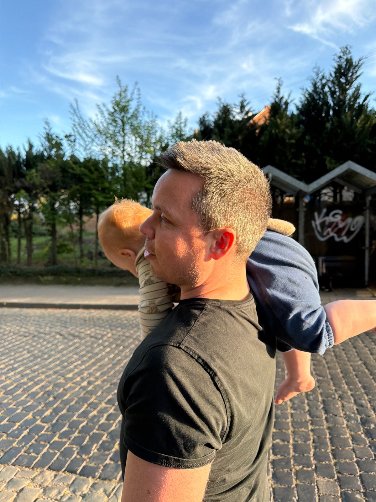 Man plays with children on cobblestone street in Meisenheim