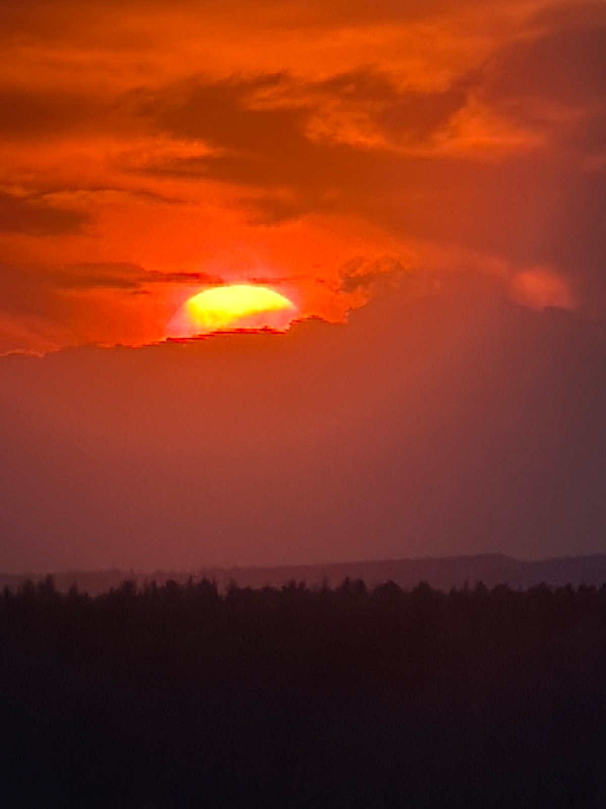 Smoky sunset observed over water near Chaikovsky, Russia