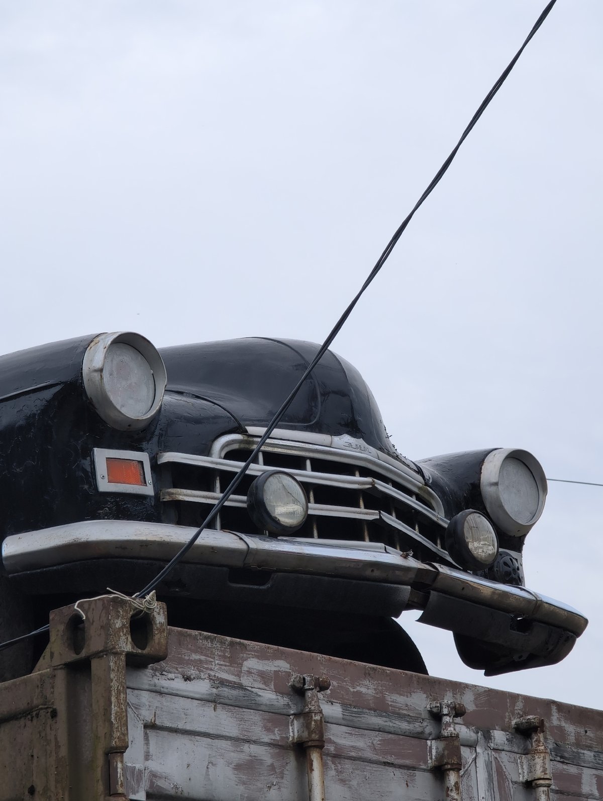 Soviet-era cars stacked on containers at a rusty outdoor lot