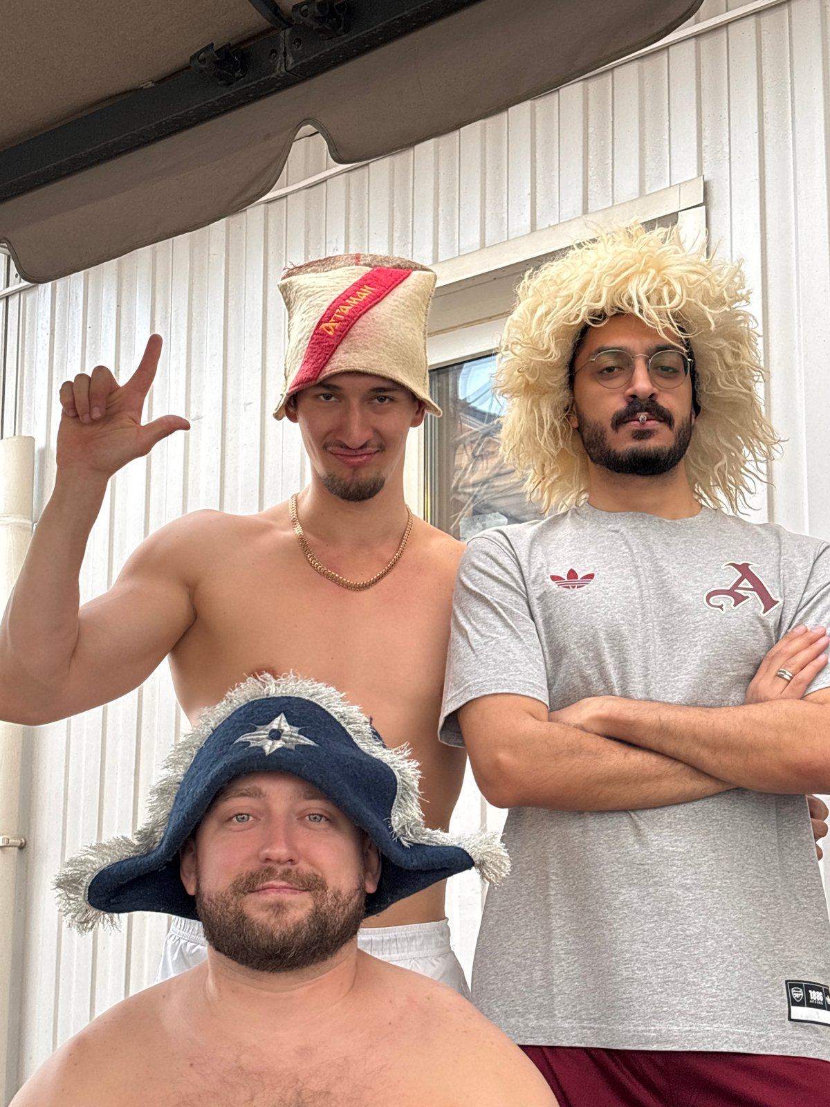 Men pose in distinctive hats during casual photo session