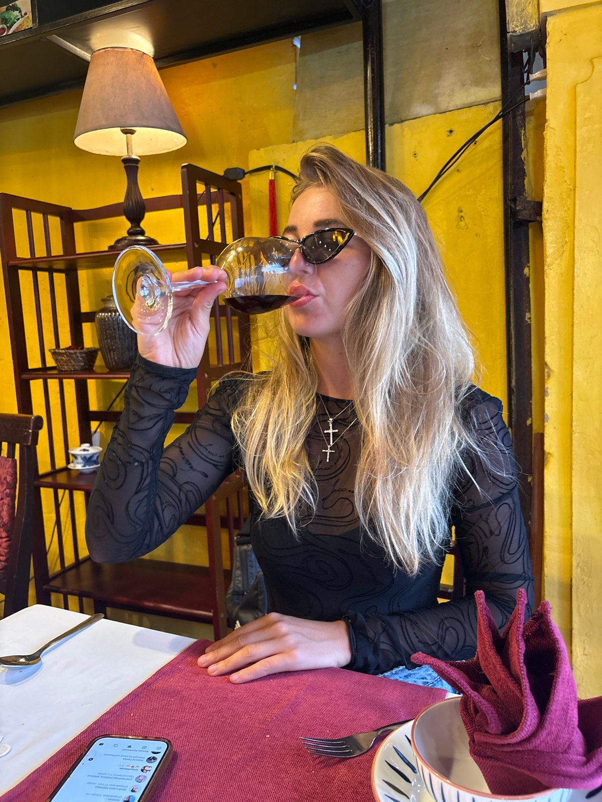 Woman dines alone at Hội An restaurant, drinks wine