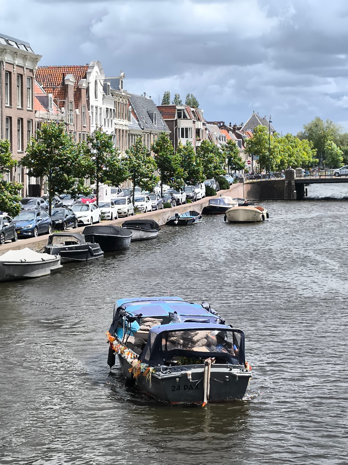 Boat travels through Haarlem canal past historic insurance building