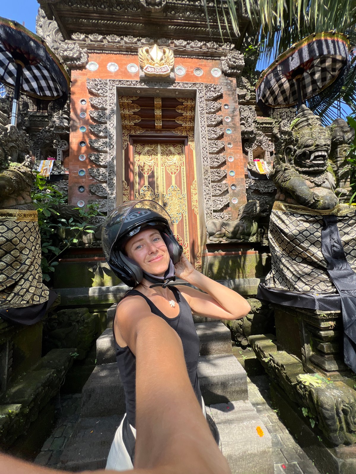 Tourist documents ornate Balinese temple architecture in Petulu village