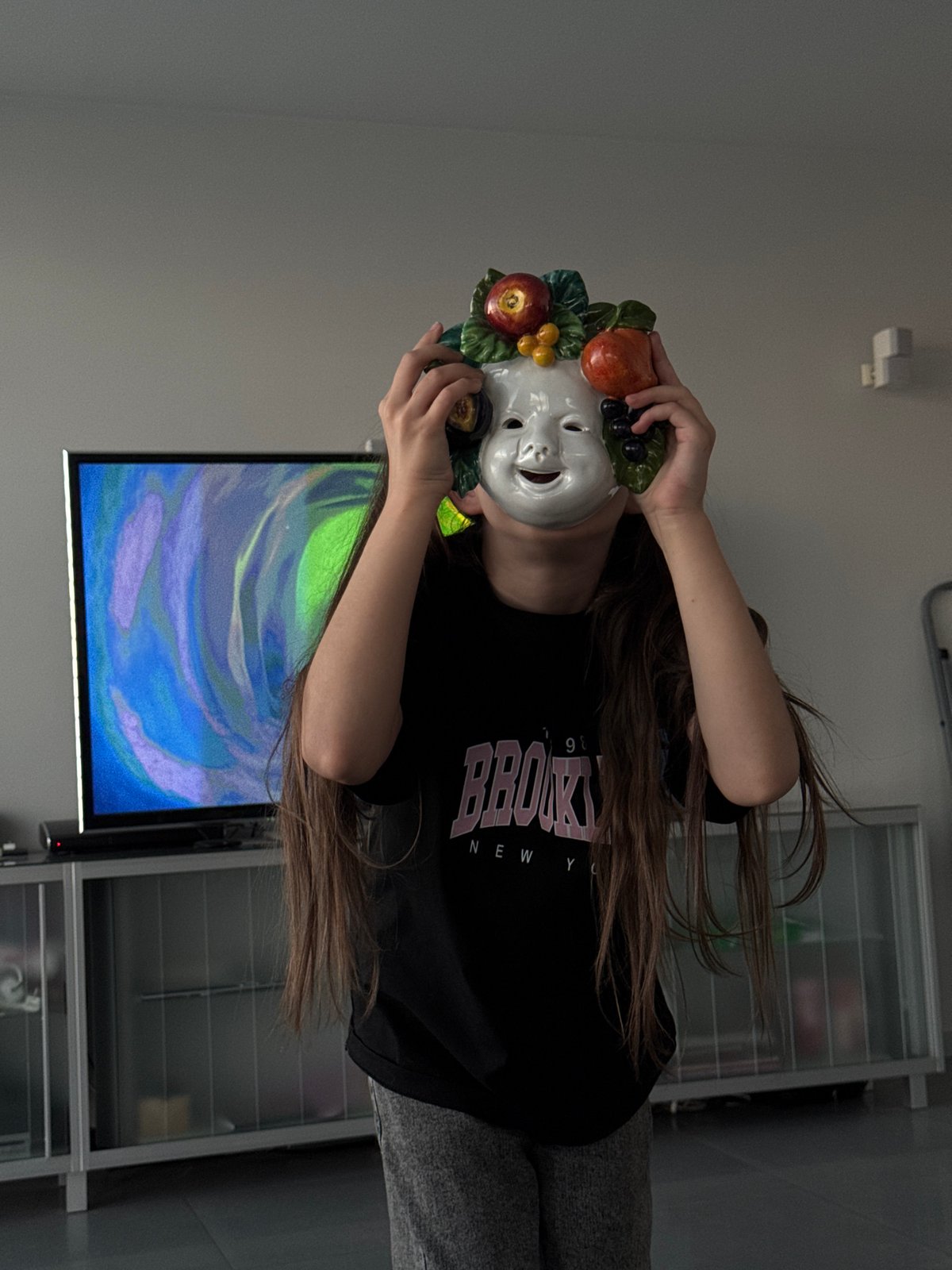 People gather with cats, fruit mask in living room