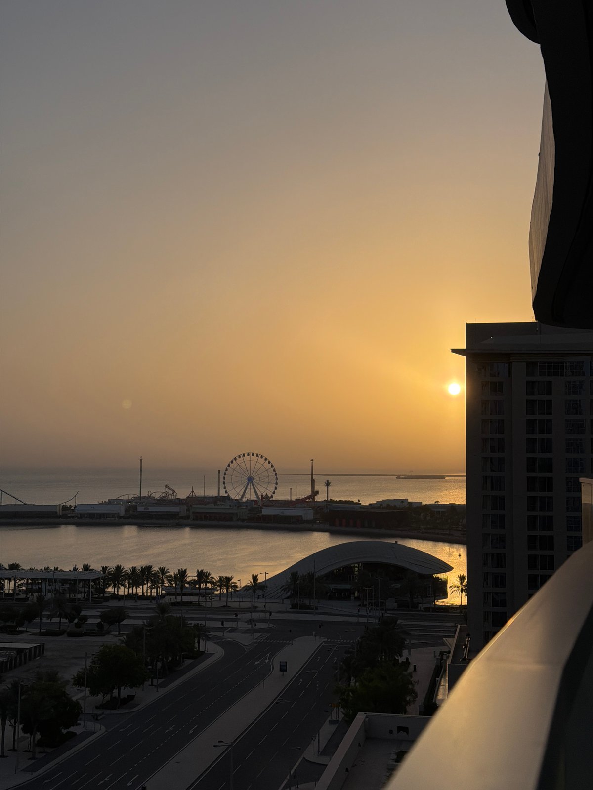 Golden hour over Lusail's waterfront, coffee in hand