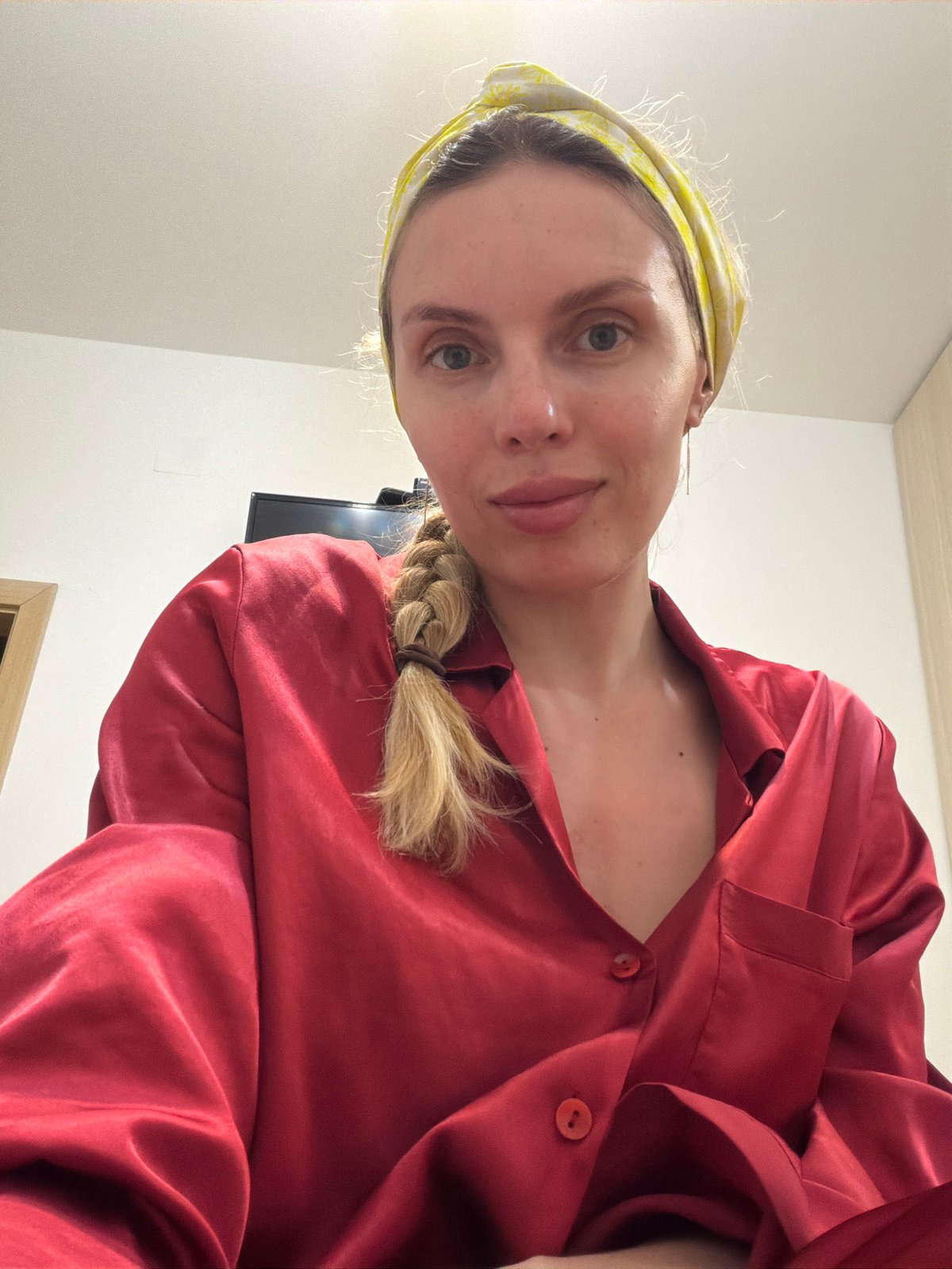 Woman applies skincare routine in Budva home evening