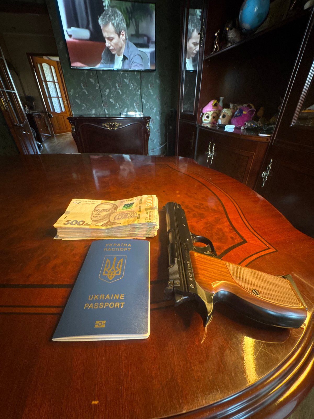 Cash, a firearm, and a passport staged across a Mykolaiv apartment