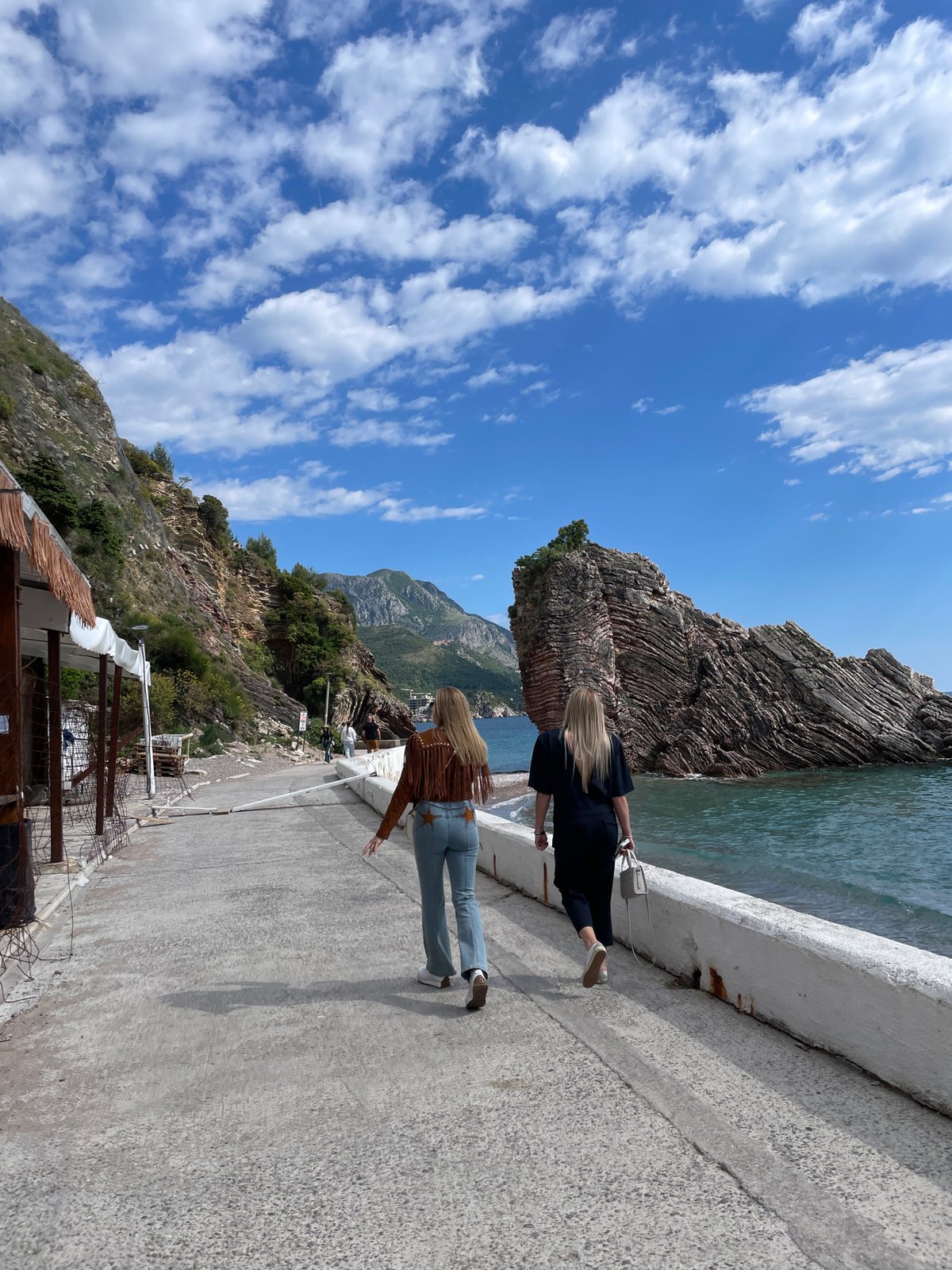 Women photograph seaside moments on Montenegro pier