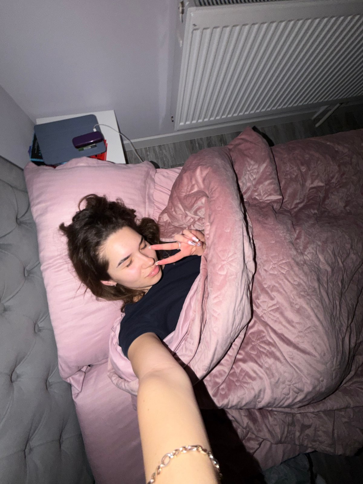 Woman relaxes in pink bedroom during evening in Dobrich