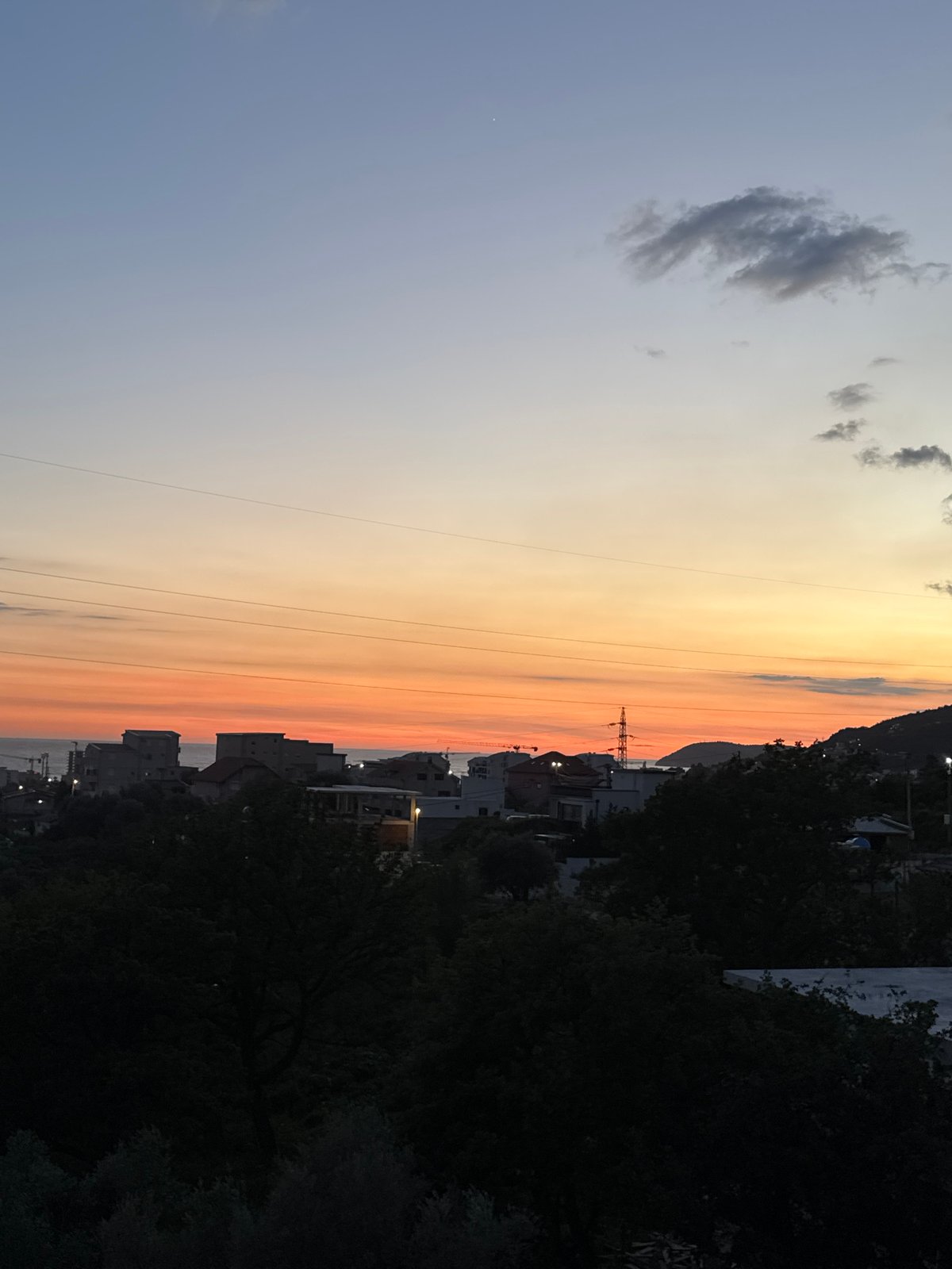 Sunset observed over Sustaš, Montenegro with electricity pylon silhouette