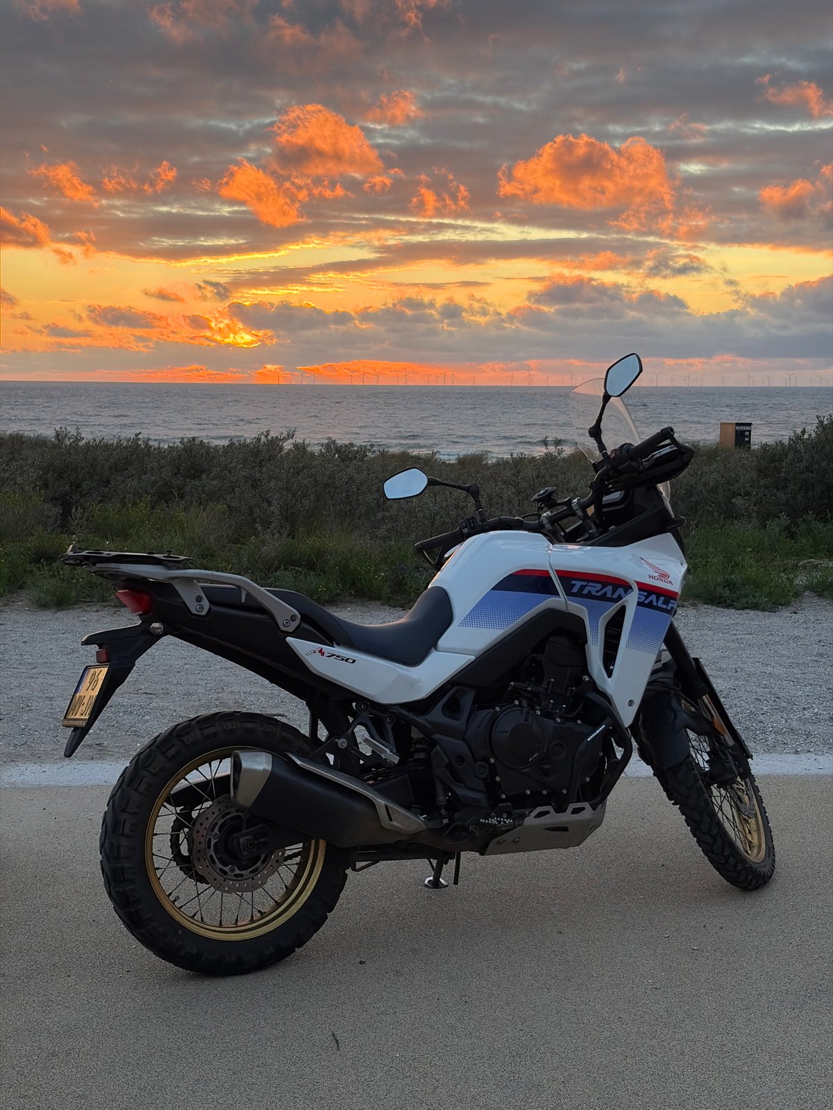 Adventure motorcycles positioned for North Sea sunset viewing