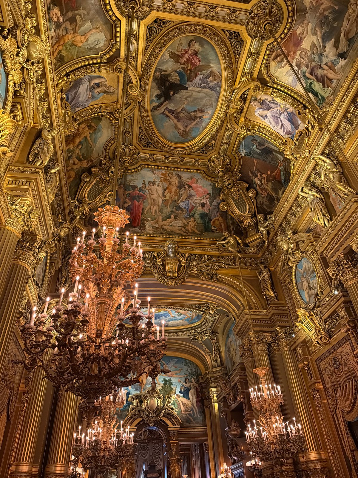 Visitor documents ornate Palais Garnier interior in Paris