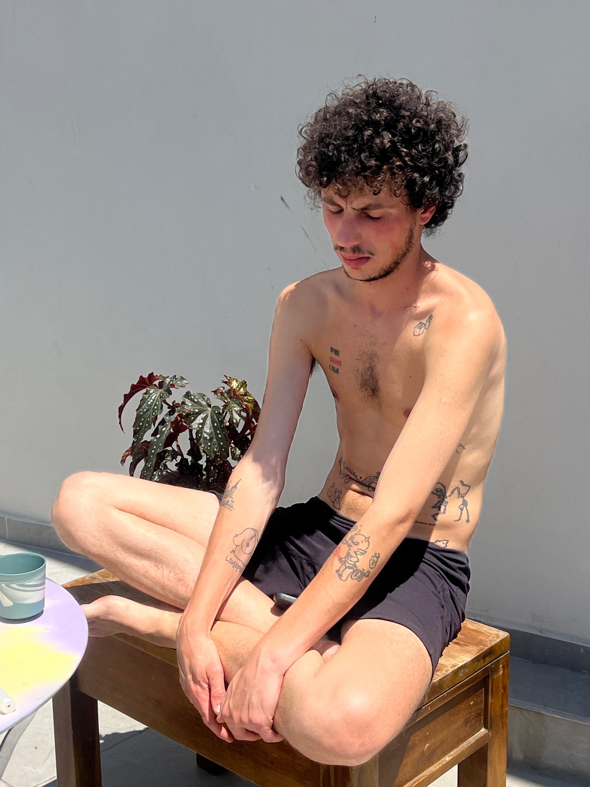 Morning breakfast scene with tattooed man, puppy in Tel Aviv