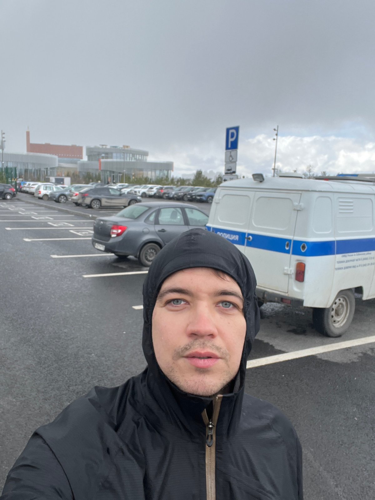 Man Takes Selfie Near Police Van in Kazan Parking Lot