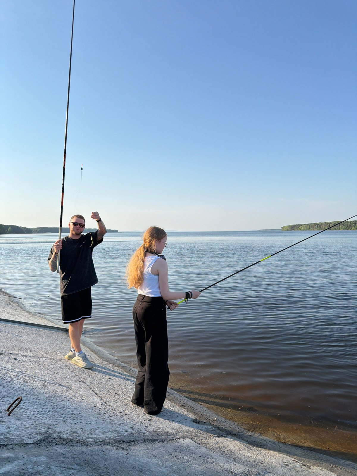 Two anglers fish from concrete pier in Chaikovsky, Russia