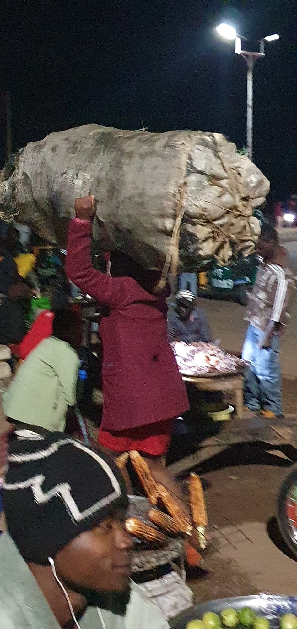 Night market activity in Bukuru, Nigeria — loads carried on heads