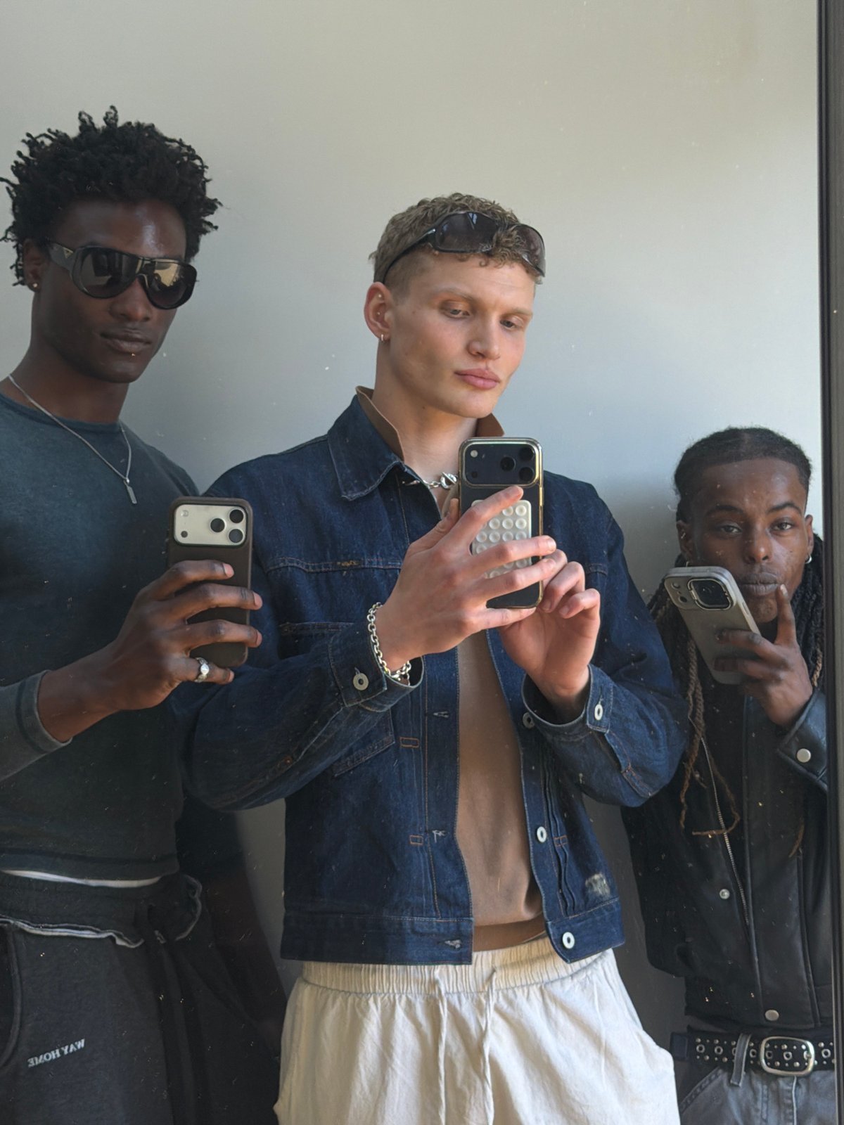 Three men take mirror selfie in London indoor location