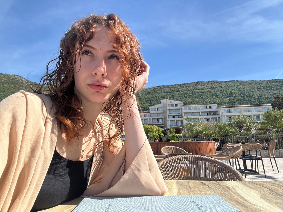 Woman photographs seaside morning in Petrovac, Montenegro
