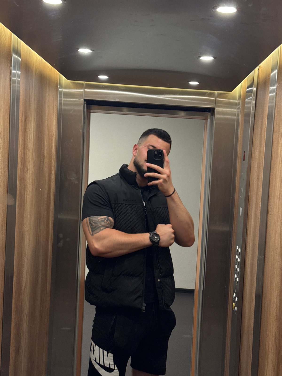 Mirror and direct selfies in a wood-paneled Sofia elevator