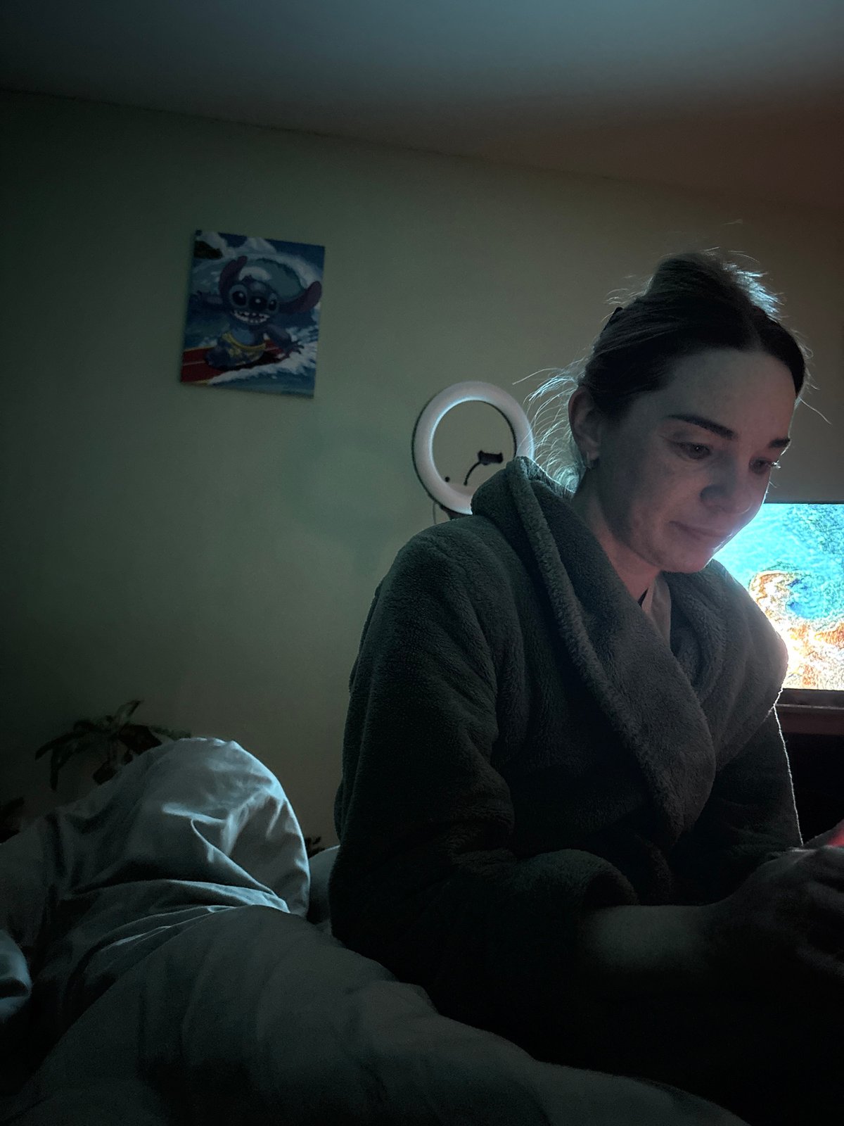 Woman documents late evening smartphone session in Russian bedroom