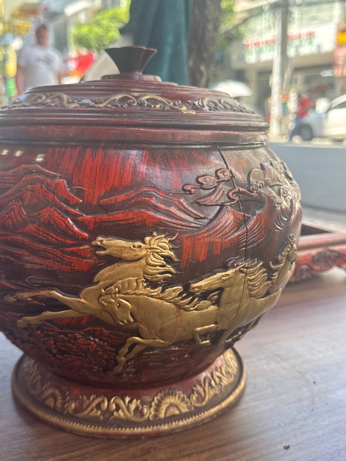 Decorative vessel and loaded motorbike documented in city area