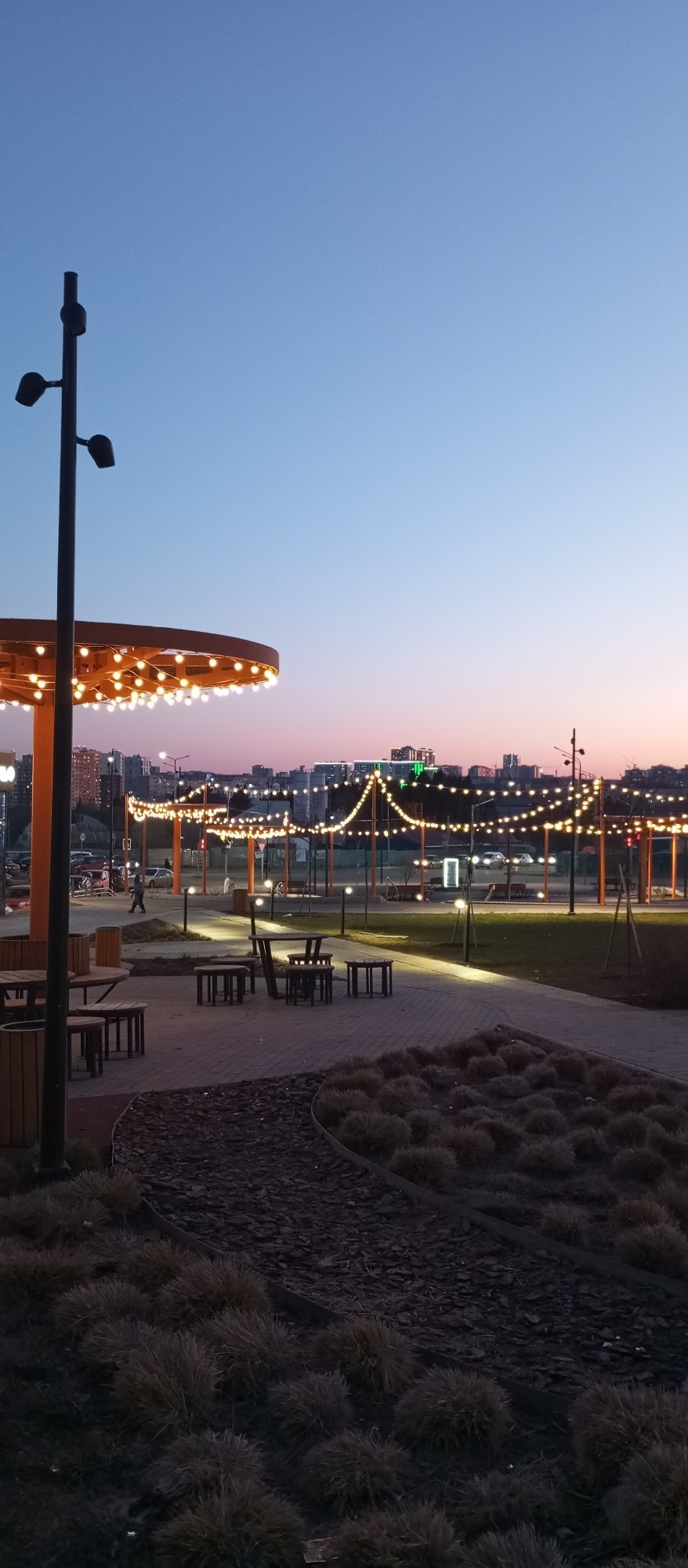 Evening lights illuminate pergola structures in Pervomaysky, Russia