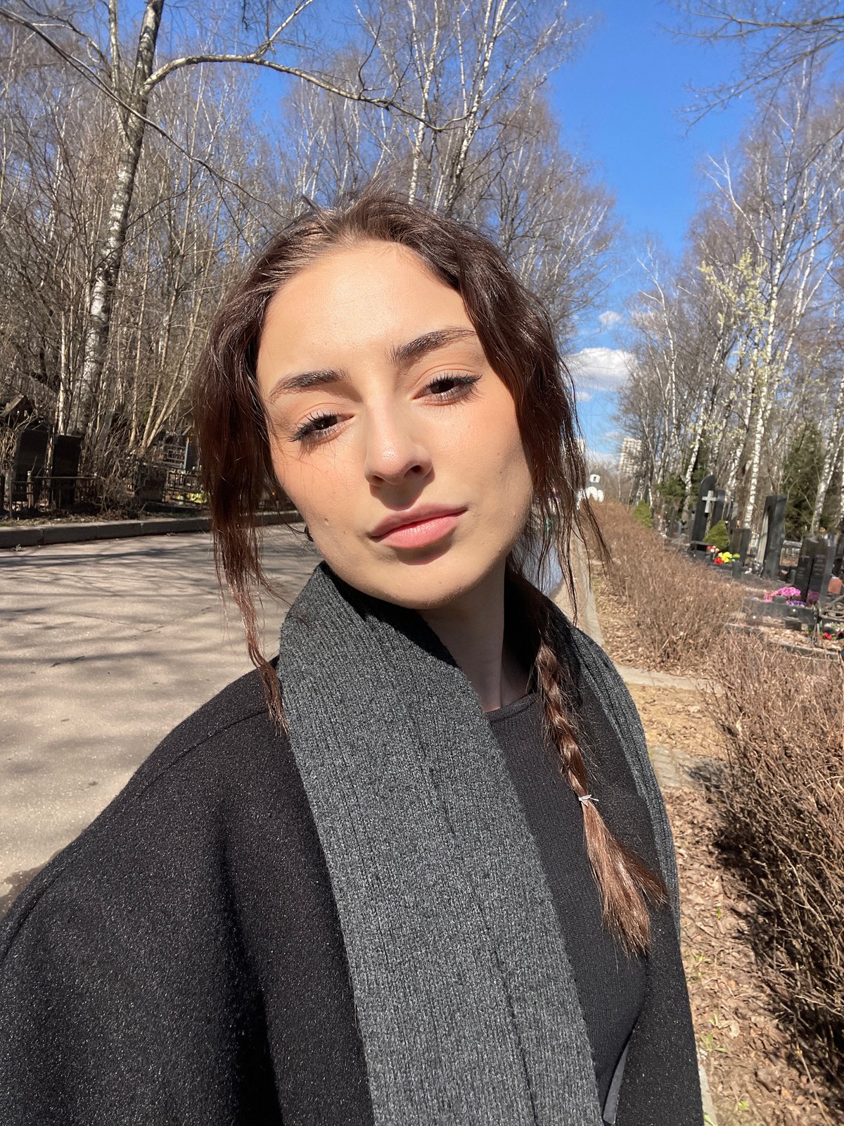 Family visits Moscow cemetery on sunny spring morning