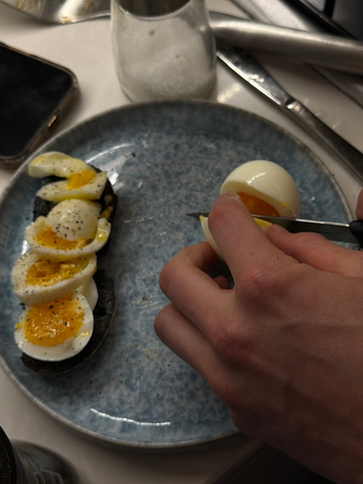 Person prepares food, slices boiled egg in London kitchen
