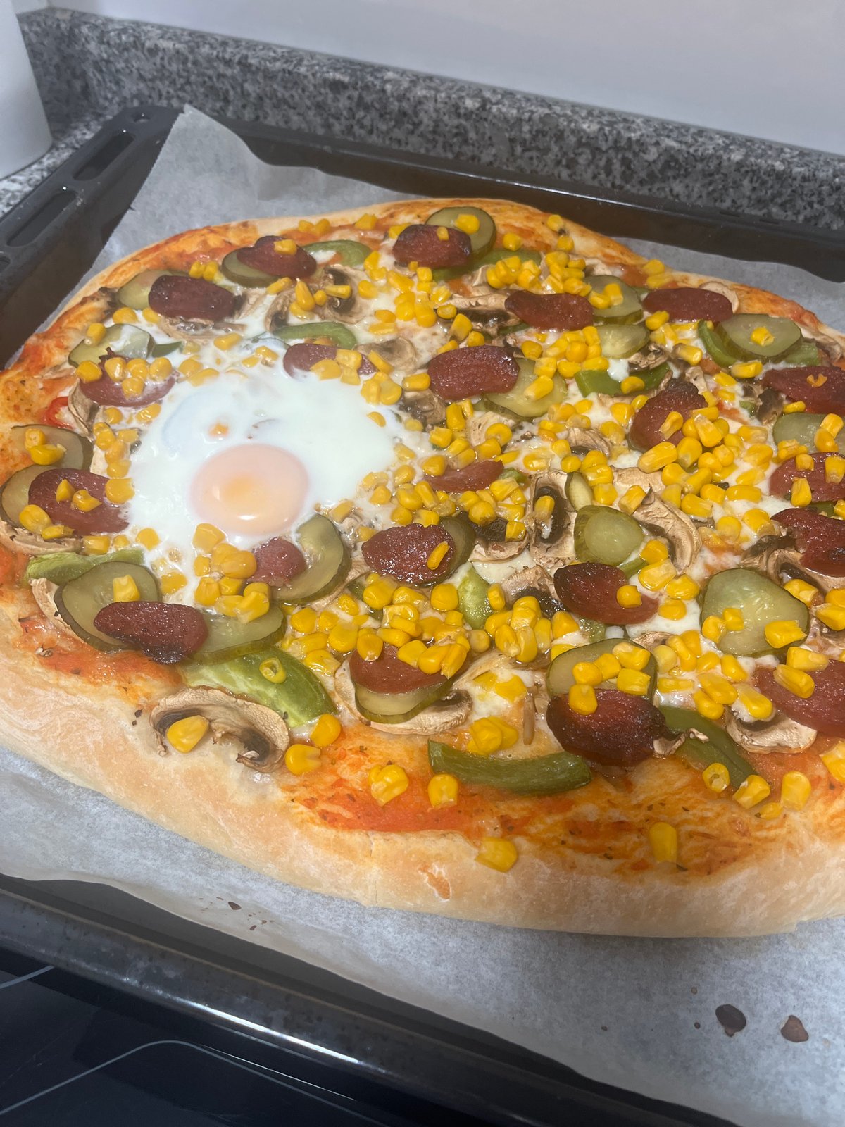 Homemade pizza with unusual toppings documented in Mogán, Spain