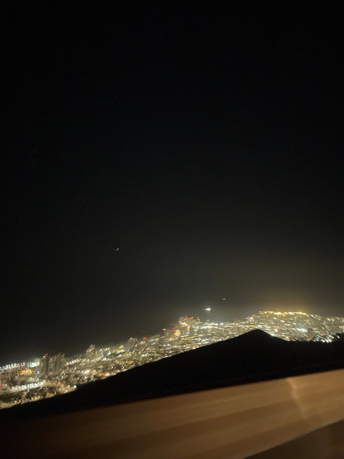 Nighttime city skyline photographed from elevated vantage point