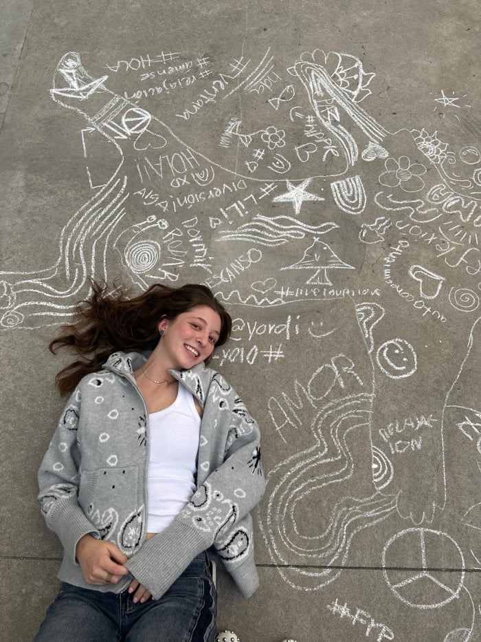 Young artists create nighttime chalk art in concrete courtyard
