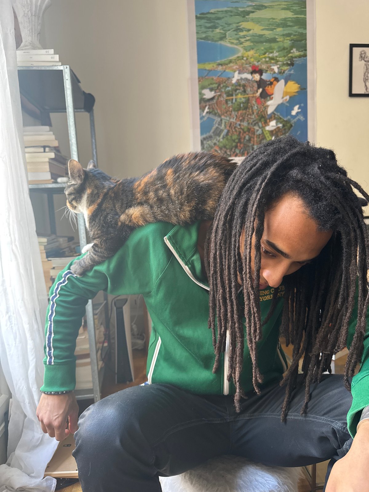 Person with dreadlocks shares quiet moment with cat in Paris