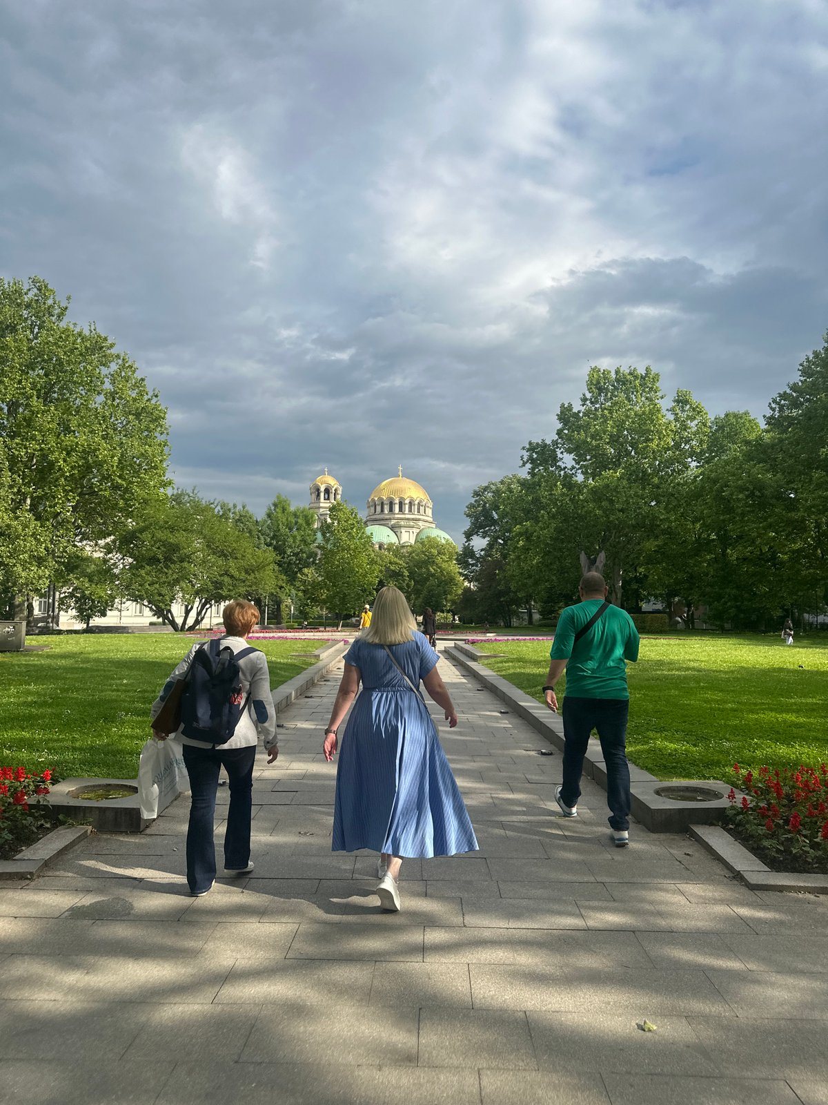Morning pedestrians captured walking through Sofia park near monument