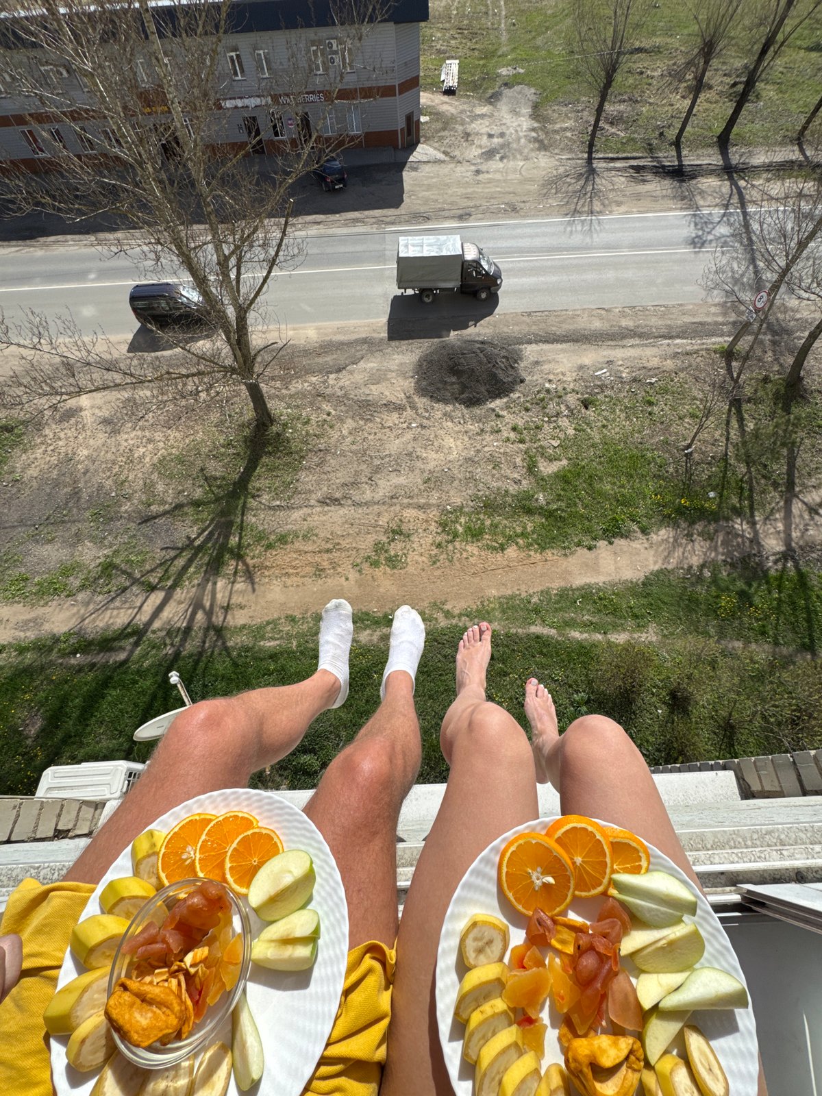 Two people share fruit meal on balcony in Russia