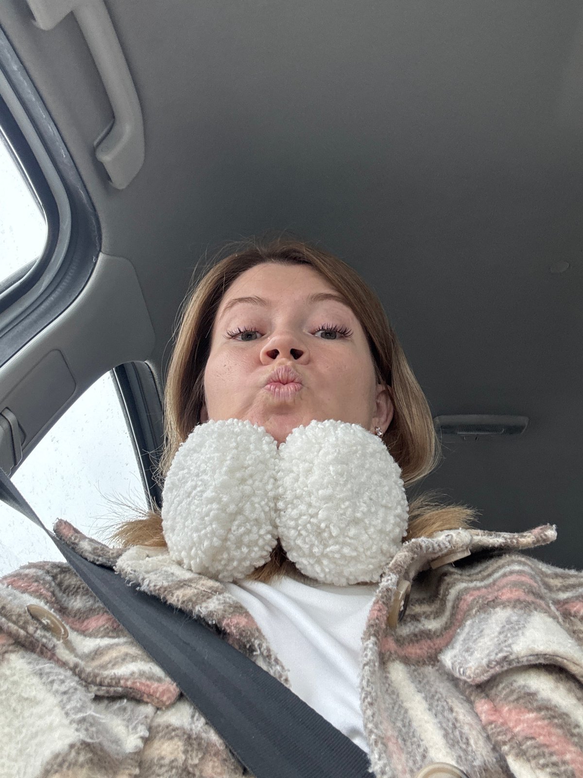Woman photographed in vehicle wearing earmuffs in Foteni, Russia