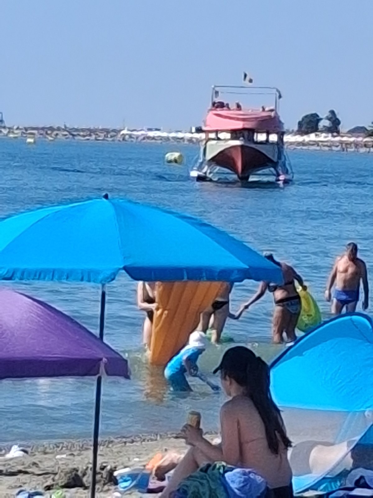 Crowded sunny beach with colorful umbrellas packed shoreside