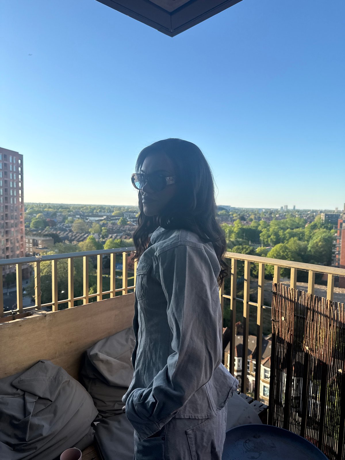 Person enjoys sunny evening city views from London balcony