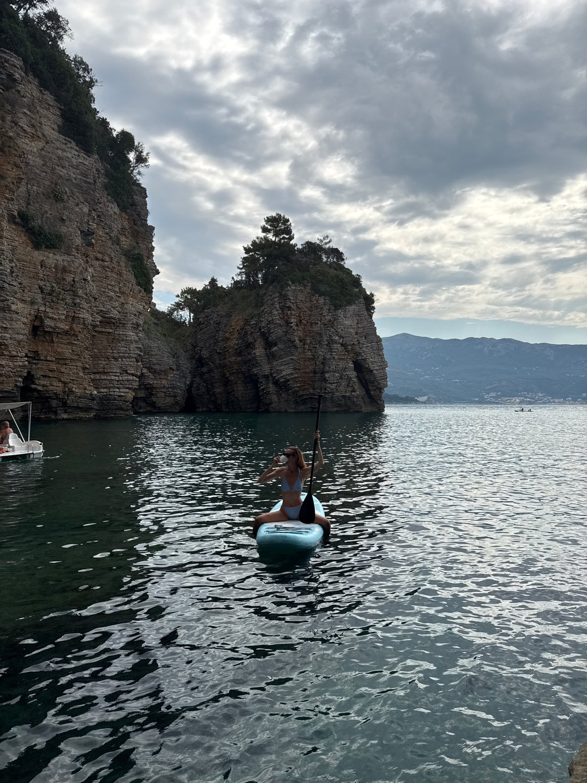 Paddleboarding the calm waters off Budva's Mogren Fort