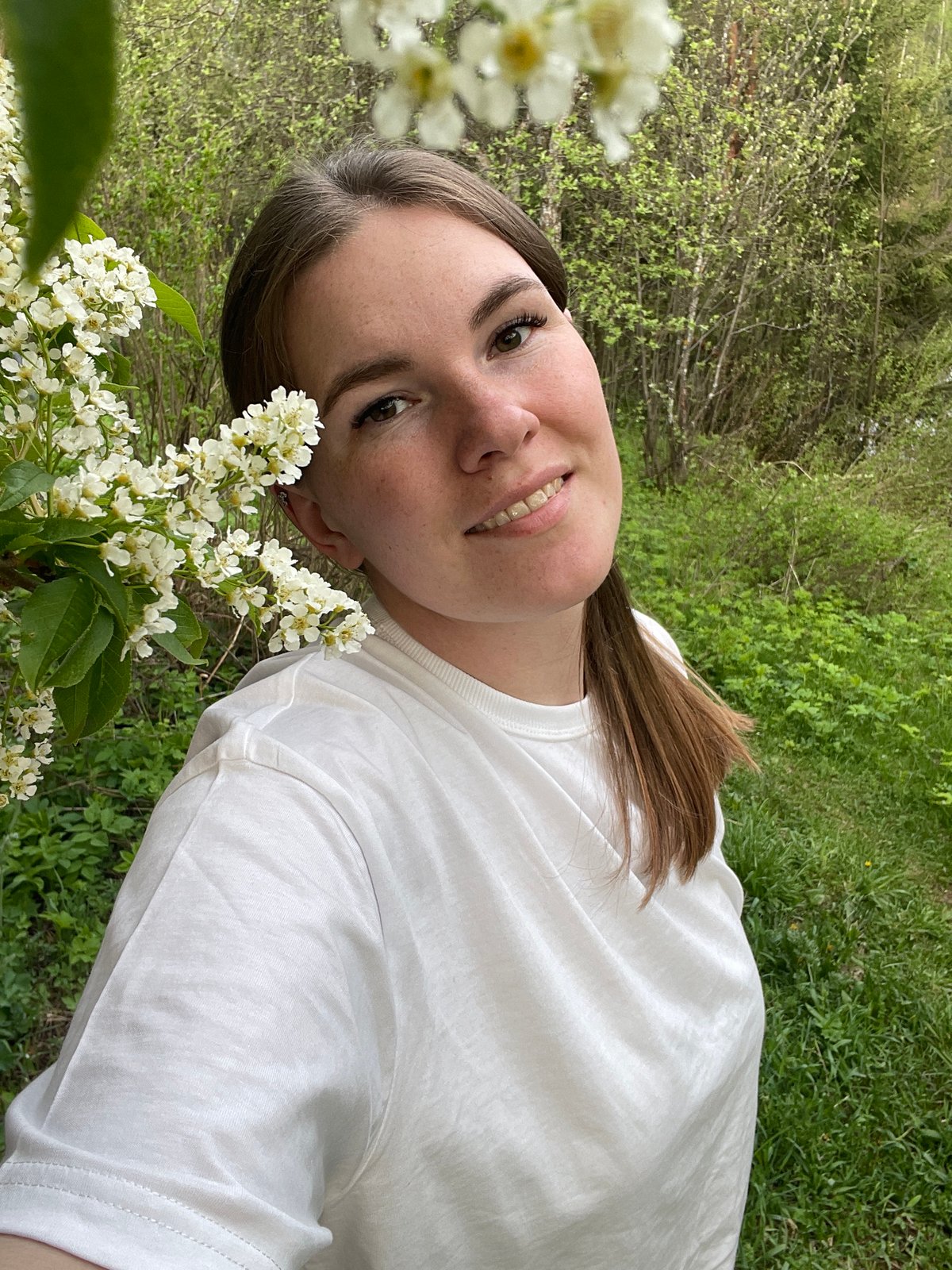 Woman poses for outdoor photo session amid flowers in Zhigalki
