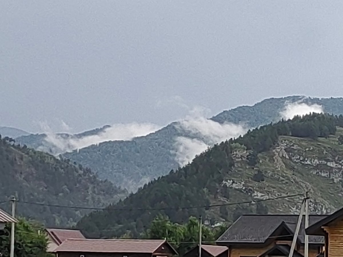 Misty mountain village in Anos, Russia on a cloudy day