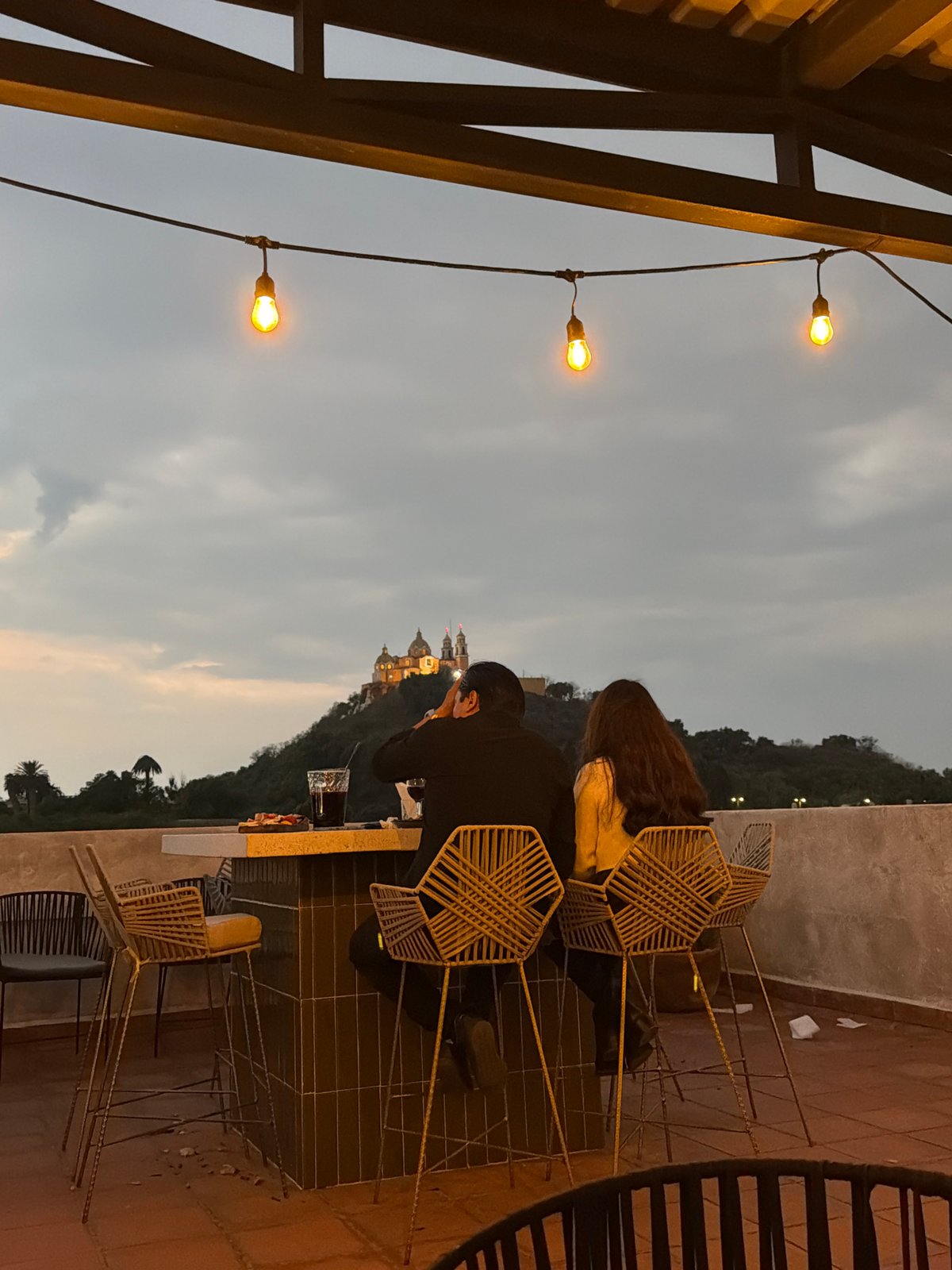 Couple photographs historic church from Cholula rooftop
