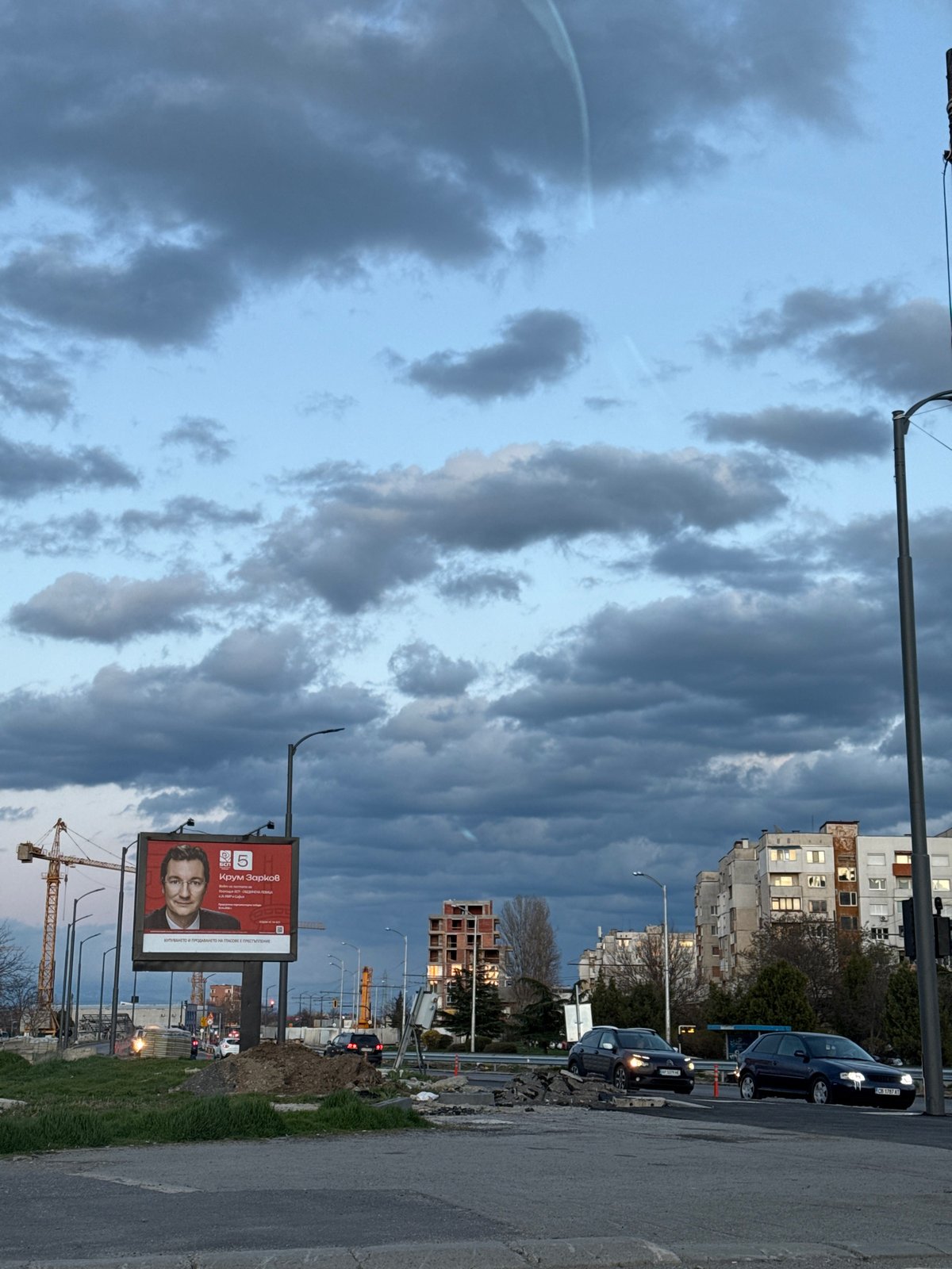 Traffic stops at red light in Sofia under stormy skies