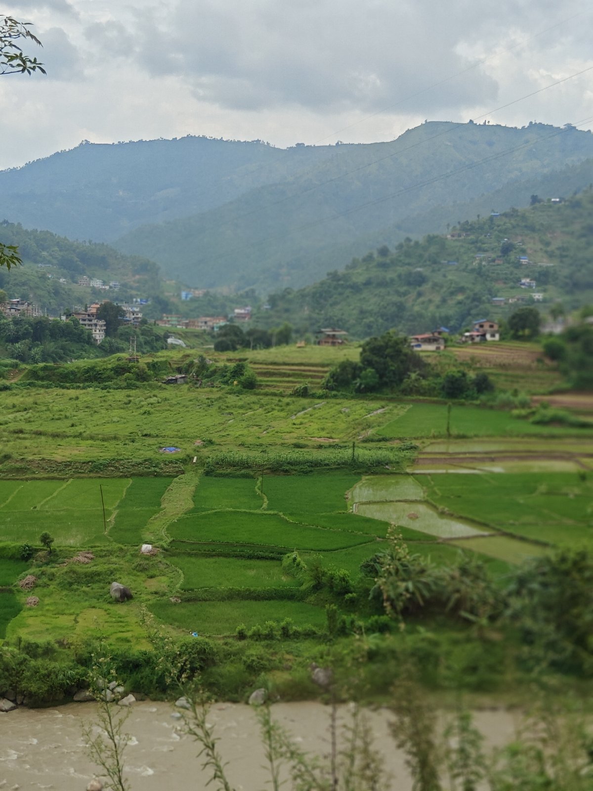 Terraced fields and a muddy river valley in rural Thakre, Nepal